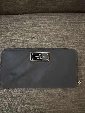 kate spade navy zip-around wallet with gold plaque and credit card slots.